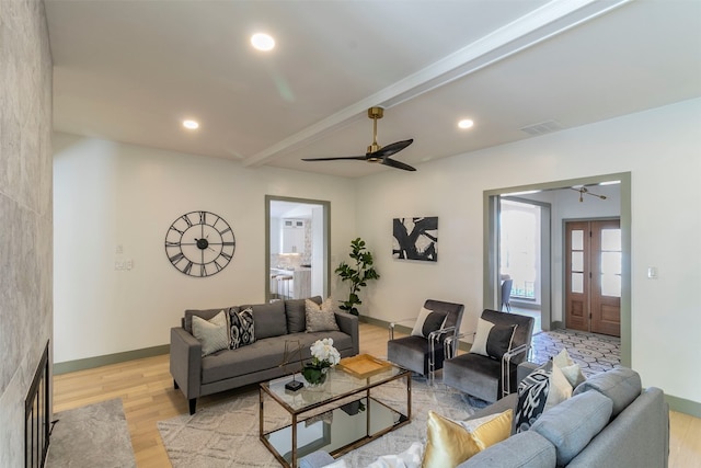 living room with ceiling fan, light hardwood / wood-style flooring, and beam ceiling