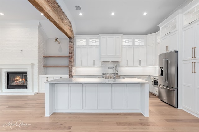 kitchen featuring light hardwood / wood-style flooring, stainless steel appliances, tasteful backsplash, and white cabinets