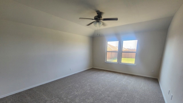 carpeted empty room featuring ceiling fan and vaulted ceiling