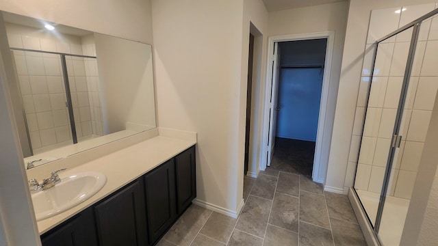 bathroom with tile patterned flooring, vanity, and walk in shower