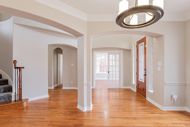 foyer entrance with light wood-type flooring and crown molding