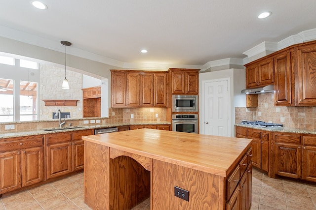 kitchen featuring tasteful backsplash, hanging light fixtures, appliances with stainless steel finishes, and sink