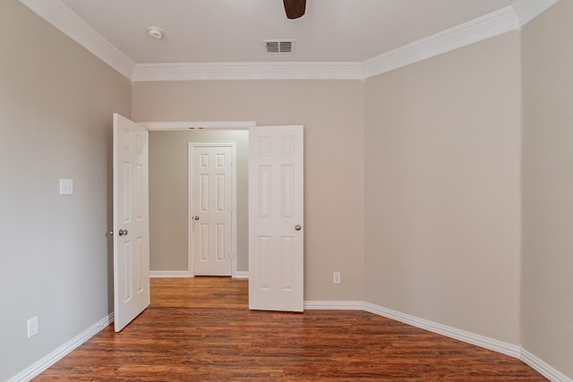 spare room featuring ceiling fan, crown molding, and dark wood-type flooring