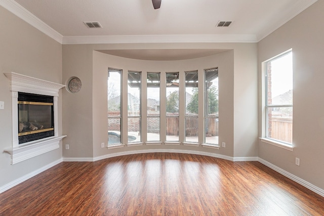 empty room featuring ceiling fan, dark wood-type flooring, and ornamental molding