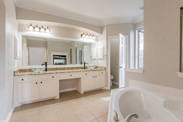 bathroom with toilet, a bathing tub, crown molding, dual bowl vanity, and tile floors