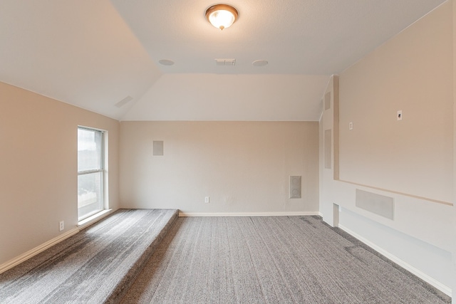 bonus room featuring vaulted ceiling and dark colored carpet