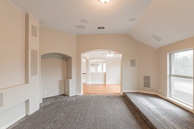 spare room with dark hardwood / wood-style floors, ceiling fan, vaulted ceiling, and a wealth of natural light