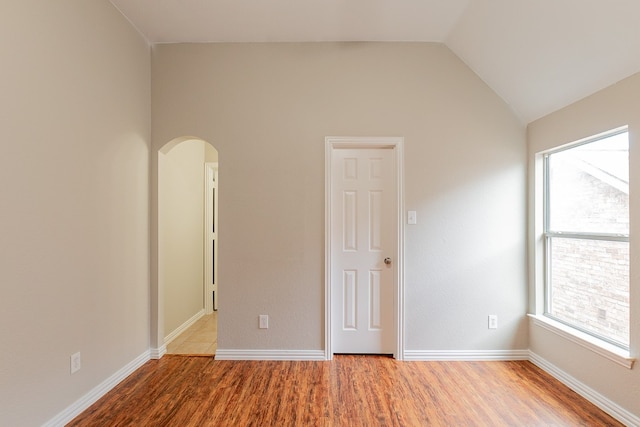 empty room featuring lofted ceiling and light wood-type flooring