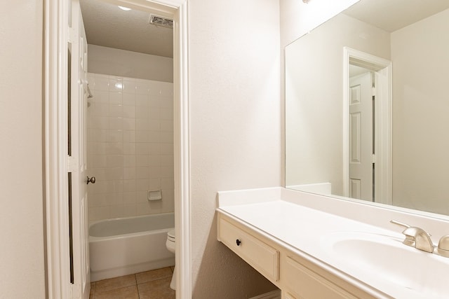 full bathroom featuring tile flooring, toilet, tiled shower / bath combo, and oversized vanity