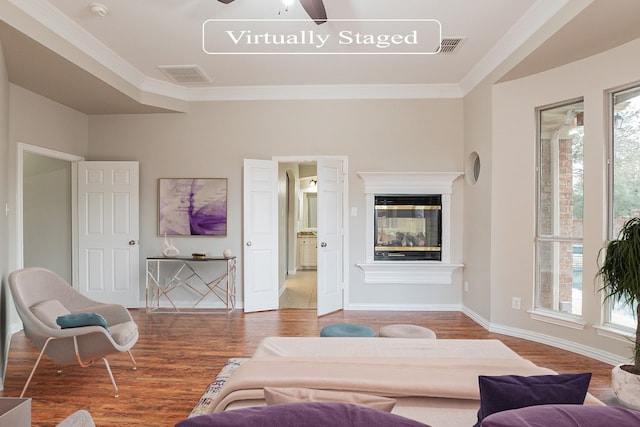 living room with ceiling fan, crown molding, plenty of natural light, and wood-type flooring