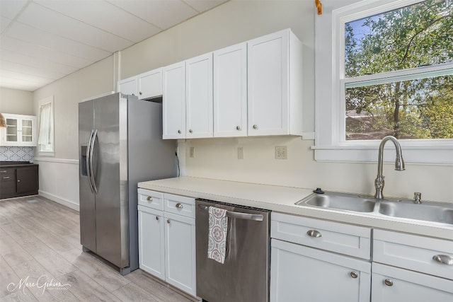 kitchen with white cabinetry, light hardwood / wood-style flooring, sink, and stainless steel appliances