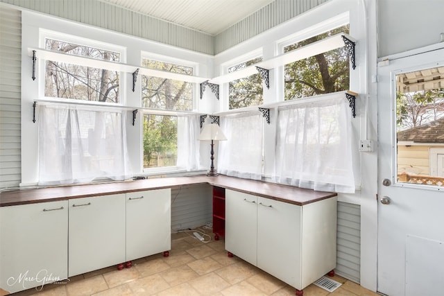 kitchen featuring white cabinets, a wealth of natural light, and light tile floors