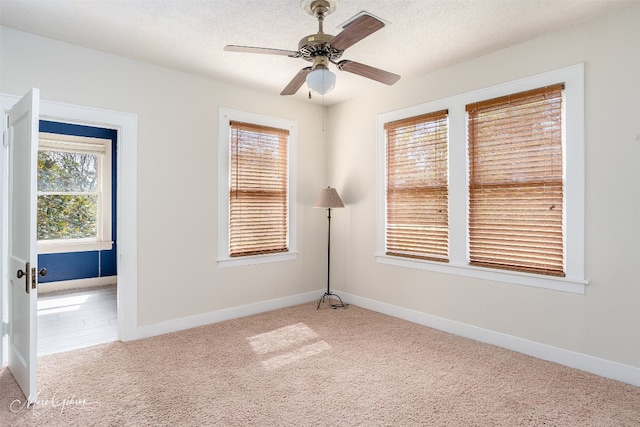 carpeted spare room with ceiling fan and a textured ceiling