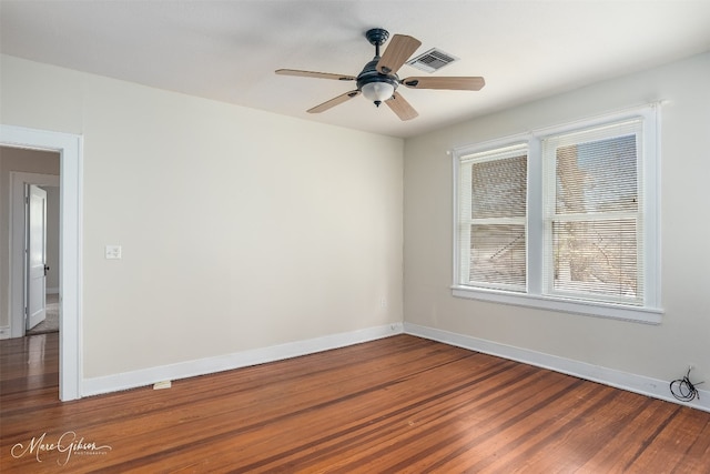 empty room with ceiling fan and dark wood-type flooring