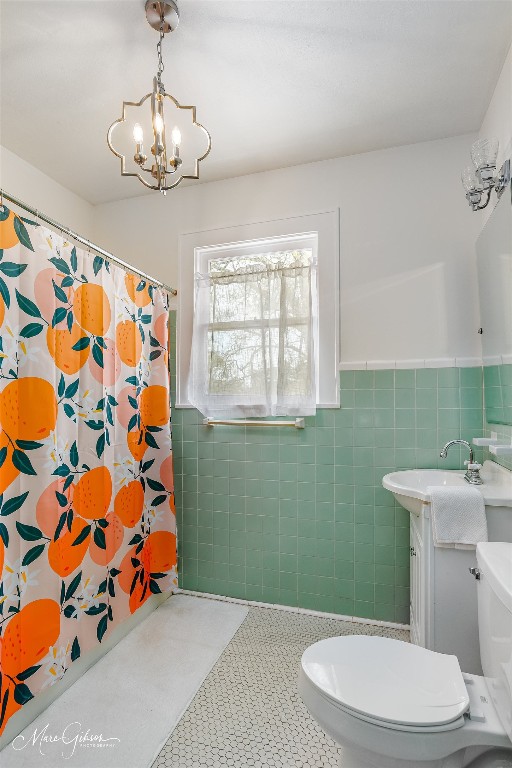 bathroom featuring tile walls, toilet, a chandelier, tile flooring, and vanity