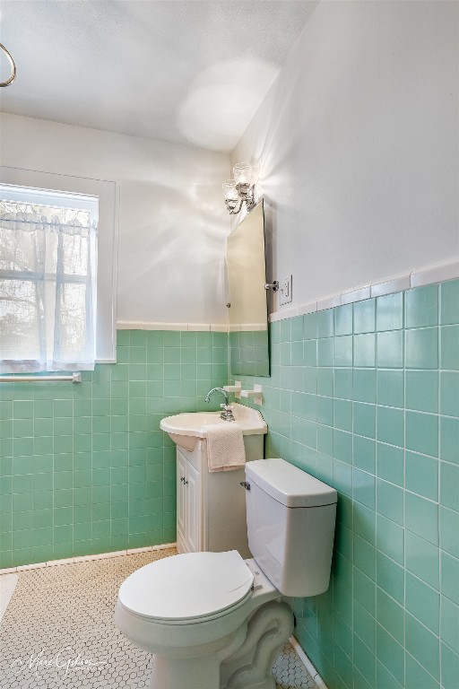 bathroom featuring tile walls, toilet, tile floors, and vanity