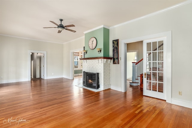 unfurnished living room featuring ceiling fan, ornamental molding, a fireplace, and hardwood / wood-style floors