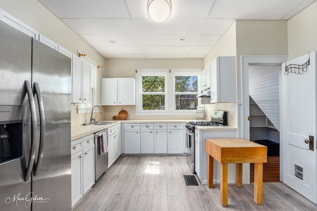 kitchen with stainless steel appliances, light wood-type flooring, and white cabinetry