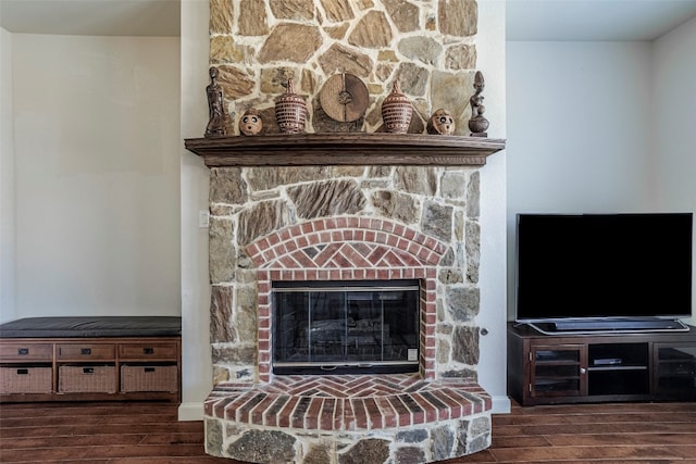 interior details featuring dark wood-type flooring and a stone fireplace