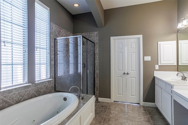 bathroom with tile floors, vanity with extensive cabinet space, and independent shower and bath