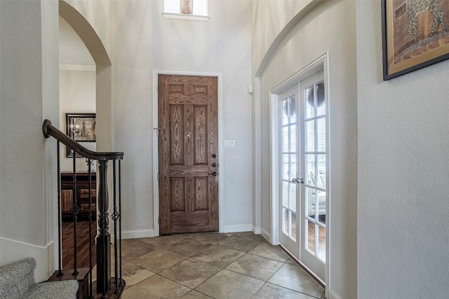 tiled entrance foyer featuring a high ceiling and french doors