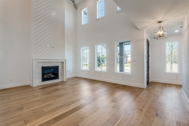 unfurnished living room with light wood-type flooring, a wealth of natural light, and a premium fireplace