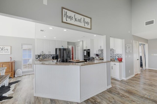 kitchen featuring a wealth of natural light, sink, vaulted ceiling, and white cabinetry