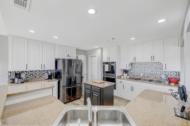 kitchen featuring a center island, light hardwood / wood-style floors, an inviting chandelier, and white cabinetry