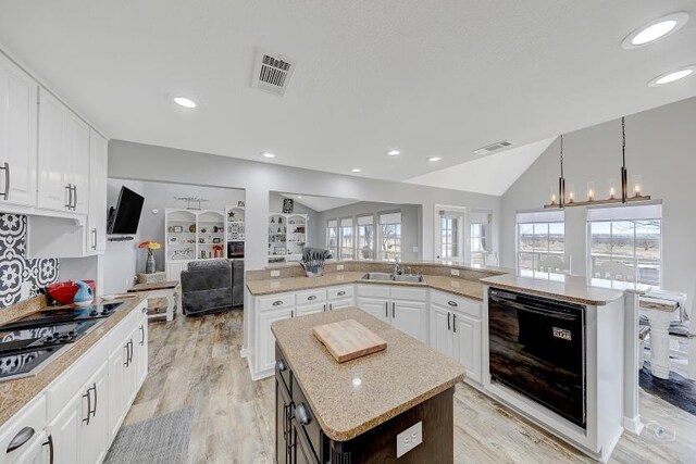 dining space featuring an inviting chandelier, light hardwood / wood-style floors, and high vaulted ceiling