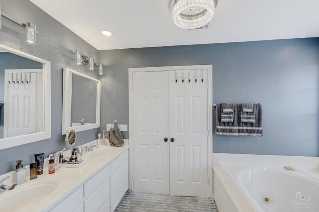 bathroom featuring vanity with extensive cabinet space, double sink, tile floors, and a bath