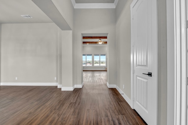 hall with dark hardwood / wood-style floors, beam ceiling, and ornamental molding