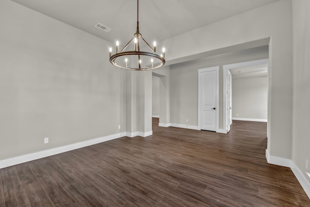 unfurnished dining area featuring dark hardwood / wood-style flooring and an inviting chandelier