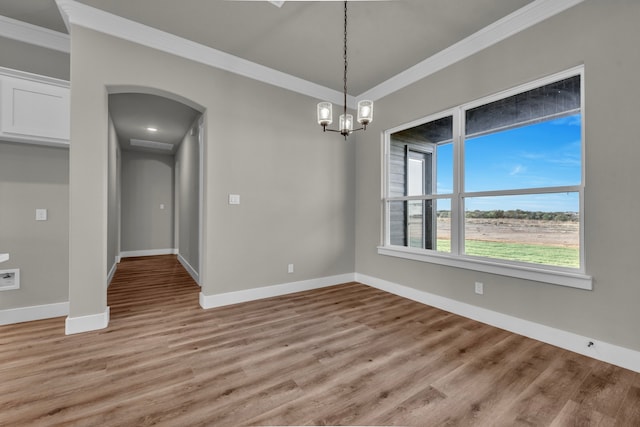 unfurnished dining area with ornamental molding, light hardwood / wood-style floors, and a notable chandelier