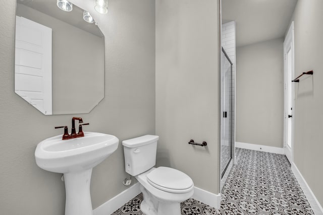 bathroom with a shower with shower door, tile patterned floors, toilet, and sink