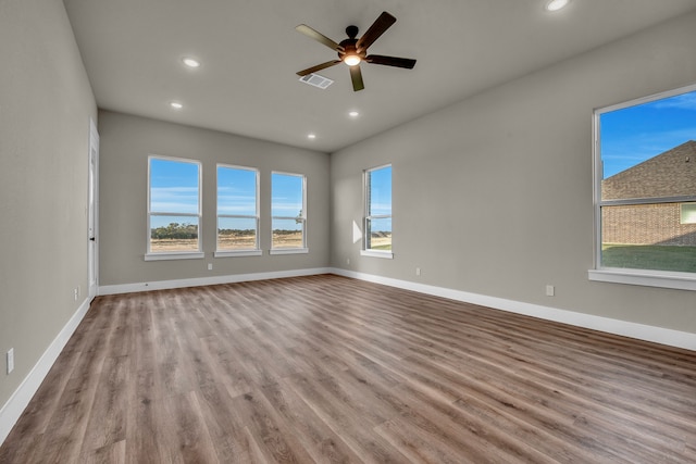 spare room featuring a water view, ceiling fan, and light hardwood / wood-style flooring