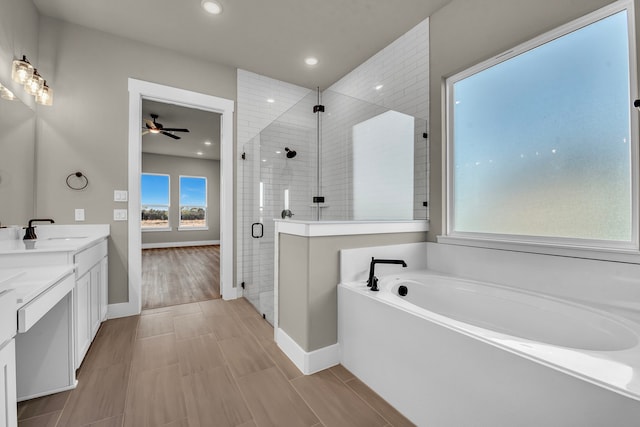 bathroom featuring hardwood / wood-style flooring, shower with separate bathtub, ceiling fan, and vanity