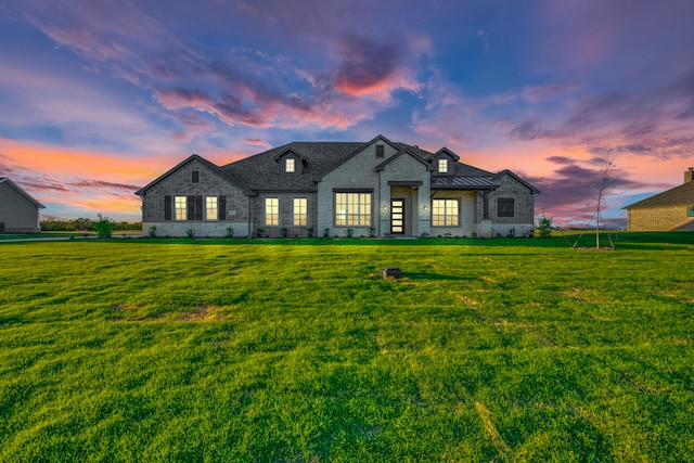 french country inspired facade with a lawn