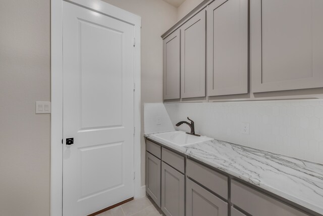 laundry room featuring light tile patterned flooring and sink