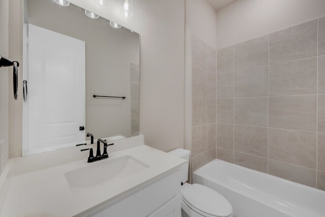 full bathroom with tiled shower / bath combo, vanity, and toilet