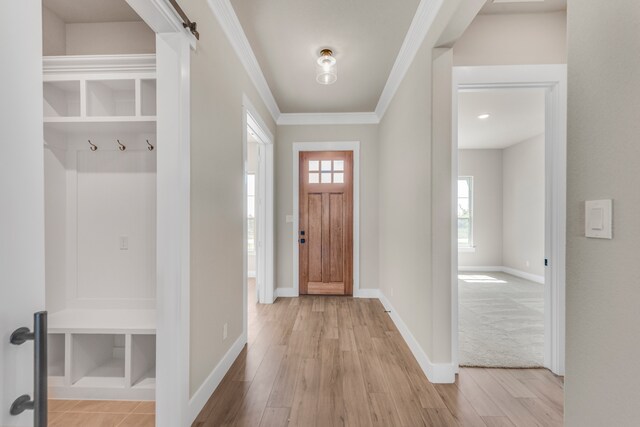 foyer with light hardwood / wood-style flooring and ornamental molding