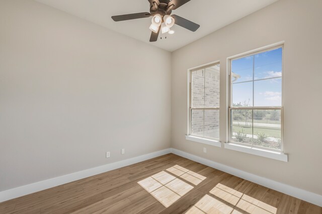 spare room featuring light hardwood / wood-style flooring, ceiling fan, and a healthy amount of sunlight