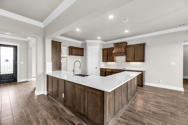 kitchen with appliances with stainless steel finishes, dark hardwood / wood-style flooring, dark brown cabinetry, and ornamental molding