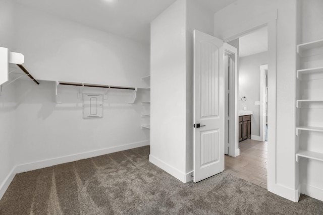 spacious closet with dark carpet