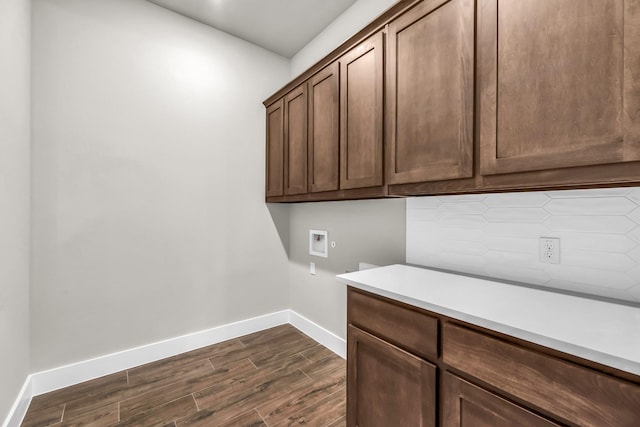 clothes washing area featuring cabinets, dark hardwood / wood-style floors, and washer hookup