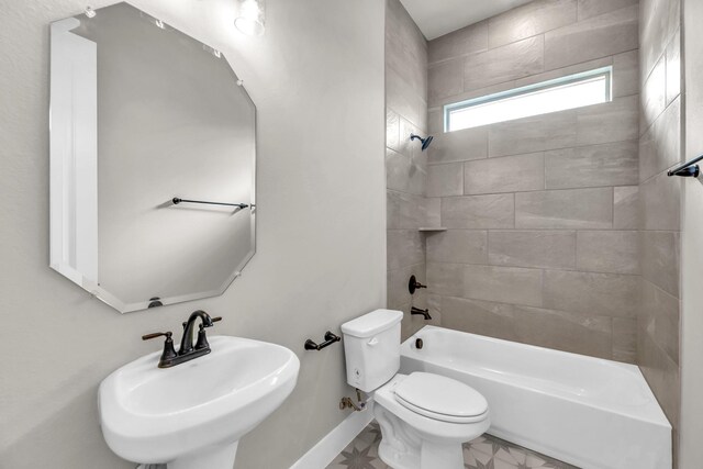 full bathroom featuring toilet, tiled shower / bath, and sink