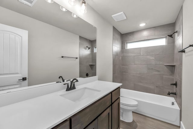 full bathroom with tiled shower / bath combo, toilet, and vanity