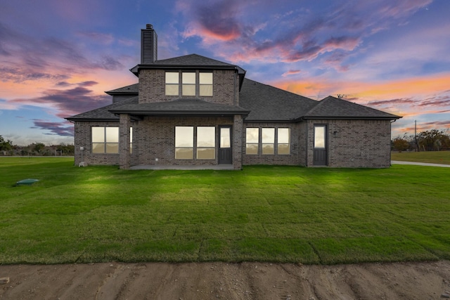 back house at dusk with a yard