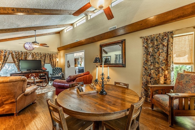 dining area featuring a ceiling fan, wood-type flooring, vaulted ceiling with beams, and a textured ceiling