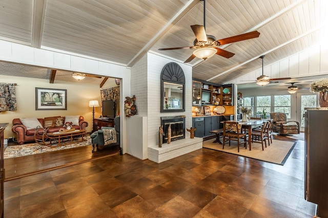 dining space featuring vaulted ceiling with beams and a fireplace