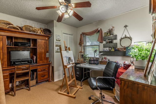 home office with light carpet, a textured ceiling, and a ceiling fan